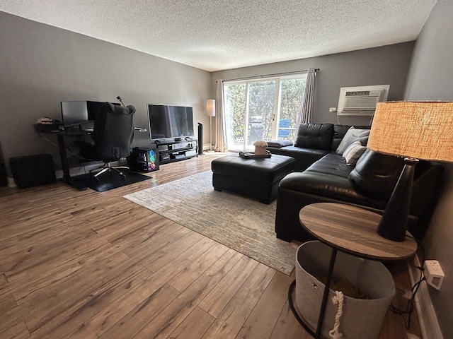 1216 S New Wilke Rd Unit 106, Arlington Heights, IL 60005 - living area with a wall mounted air conditioner, a textured ceiling, and hardwood / wood-style floors