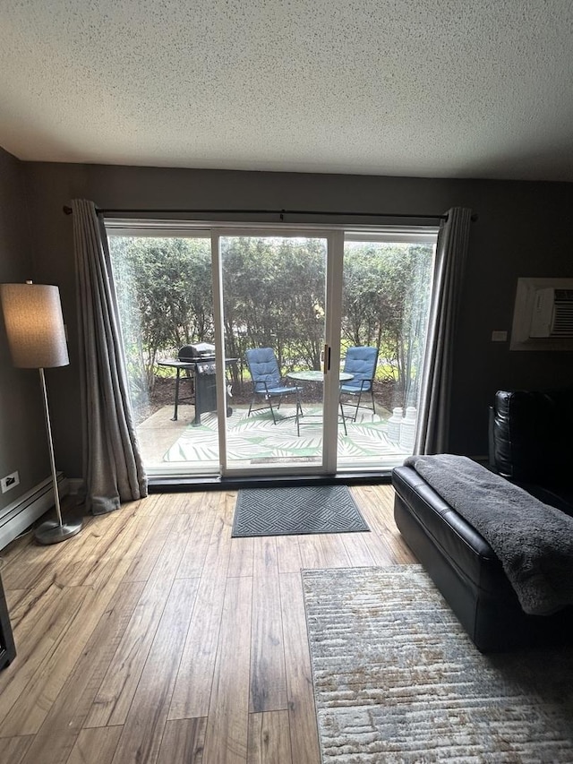 1216 S New Wilke Rd Unit 106, Arlington Heights, IL 60005 - doorway to outside featuring a textured ceiling, a wall unit AC, and hardwood / wood-style flooring