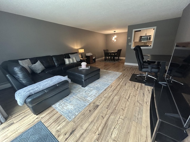 1216 S New Wilke Rd Unit 106, Arlington Heights, IL 60005 - living area featuring baseboards, a textured ceiling, and wood finished floors