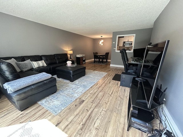 1216 S New Wilke Rd Unit 106, Arlington Heights, IL 60005 - living area with a textured ceiling, baseboards, and light wood finished floors