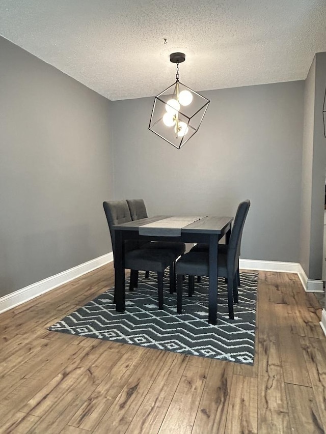 1216 S New Wilke Rd Unit 106, Arlington Heights, IL 60005 - dining area with a textured ceiling, a notable chandelier, baseboards, and hardwood / wood-style flooring