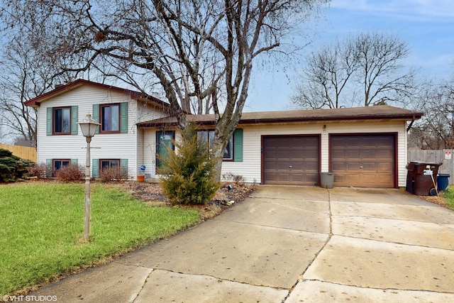 tri-level home featuring an attached garage, a front yard, and concrete driveway