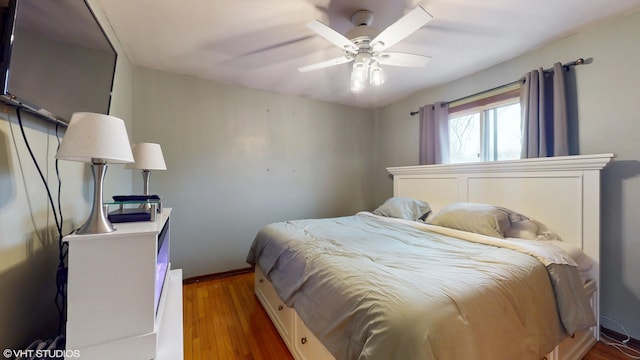 bedroom featuring a ceiling fan, baseboards, and wood finished floors