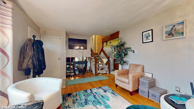living area featuring stairs and wood finished floors