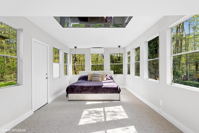 carpeted bedroom with a wall unit AC, multiple windows, and baseboards