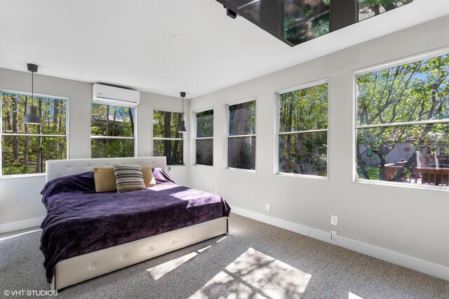 bedroom featuring multiple windows, baseboards, and a wall unit AC