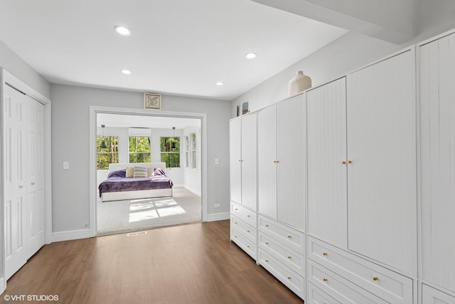 spacious closet featuring dark wood-style floors and a wall unit AC
