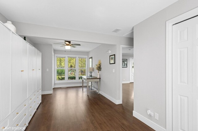 interior space with ceiling fan, dark wood finished floors, and baseboards