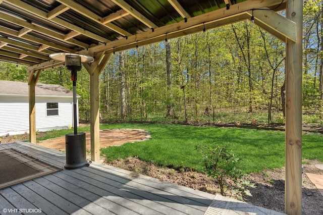 wooden deck featuring a lawn and a view of trees