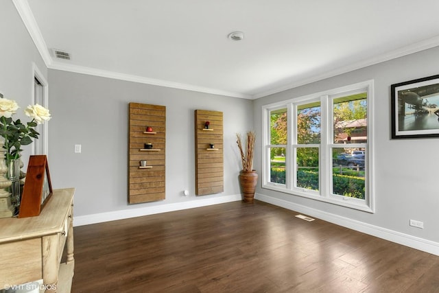 unfurnished dining area featuring crown molding, baseboards, and dark wood-type flooring
