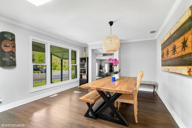 dining space with ornamental molding, wood finished floors, and baseboards