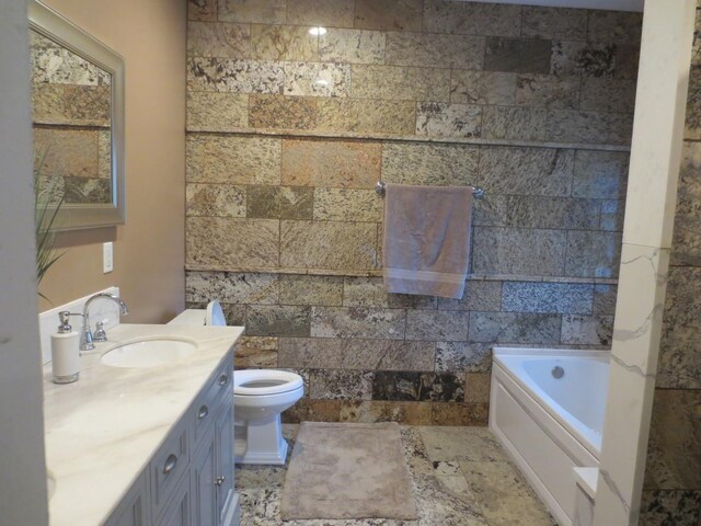full bath with vanity, stone finish floor, a garden tub, and toilet