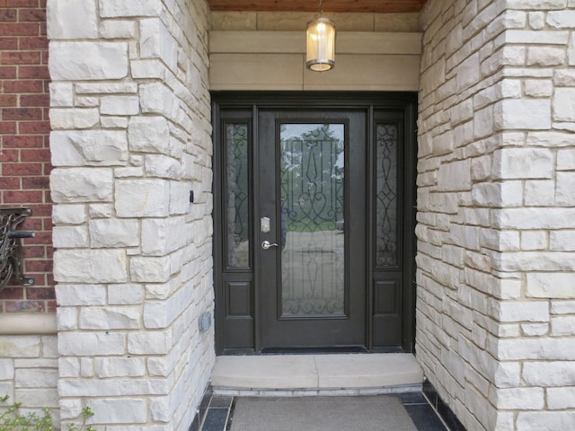 entrance to property featuring brick siding