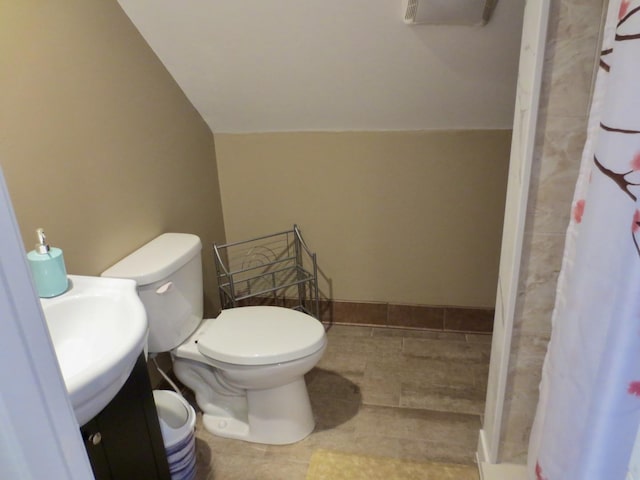 bathroom featuring vanity, vaulted ceiling, a stall shower, and toilet