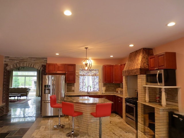 kitchen with a breakfast bar, recessed lighting, a sink, appliances with stainless steel finishes, and backsplash