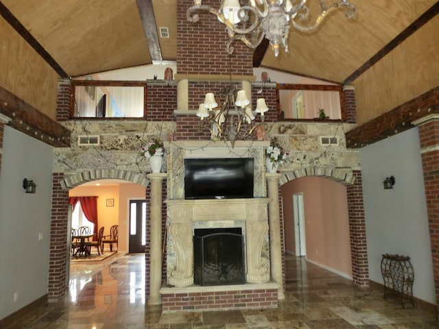 unfurnished living room with baseboards, a notable chandelier, a fireplace, and visible vents