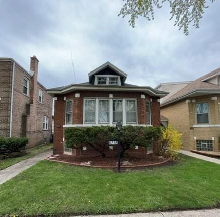 view of front of property featuring brick siding and a front yard