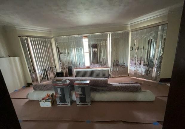 bedroom with crown molding and radiator heating unit