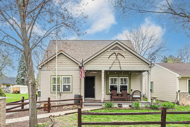 3010 Mary Ln, Mchenry, IL 60051 - bungalow featuring a fenced front yard, roof with shingles, covered porch, and a front lawn