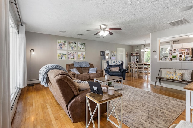 310 S Elm St, Saint Joseph, IL 61873 - living area featuring visible vents, a baseboard radiator, a textured ceiling, and ceiling fan