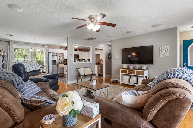 310 S Elm St, Saint Joseph, IL 61873 - living room featuring ceiling fan, light wood-type flooring, and a textured ceiling