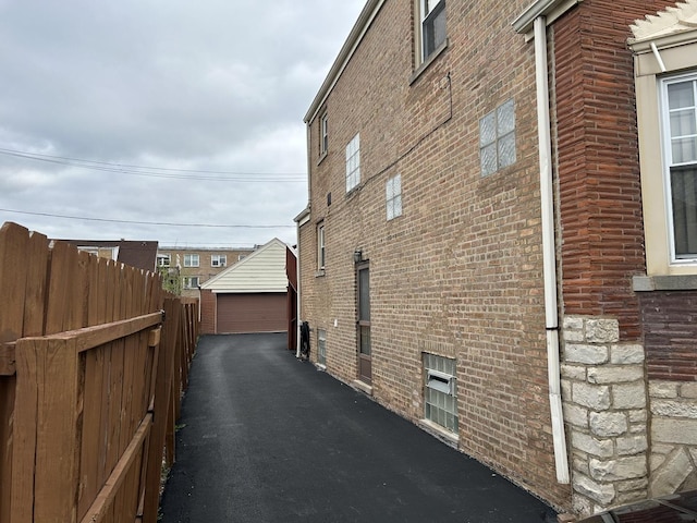 7172 W Armitage Ave, Chicago, IL 60707 - view of home's exterior featuring brick siding, fence, an outbuilding, and a garage