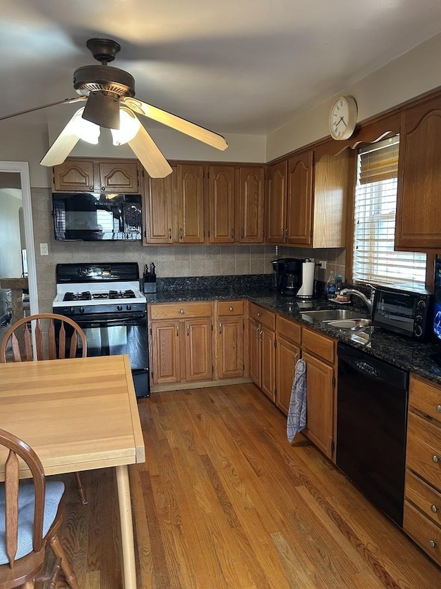 7172 W Armitage Ave, Chicago, IL 60707 - kitchen featuring a ceiling fan, dark countertops, arched walkways, a sink, and black appliances