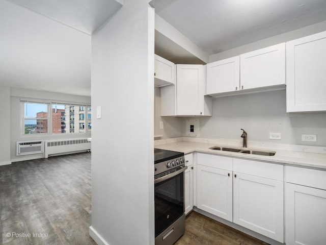 kitchen with white cabinets, a sink, stainless steel range with electric stovetop, radiator heating unit, and dark wood-style floors