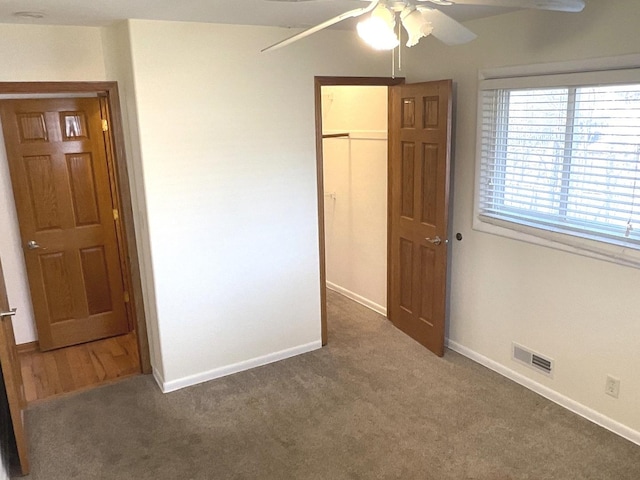 unfurnished bedroom featuring visible vents, carpet, baseboards, and a closet