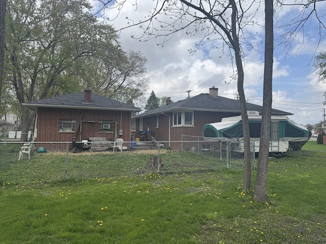 rear view of house with brick siding, a yard, and fence private yard