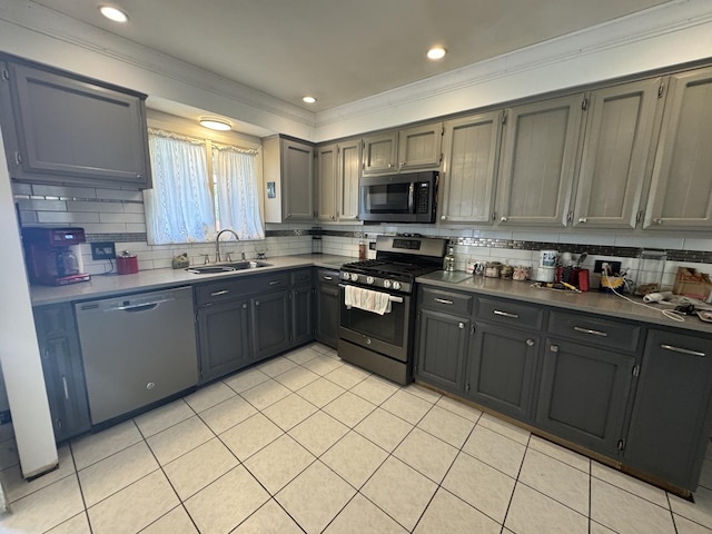 kitchen featuring ornamental molding, backsplash, a sink, appliances with stainless steel finishes, and light tile patterned floors