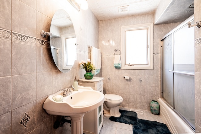14650 Lamon Ave, Midlothian, IL 60445 - full bathroom featuring visible vents, tile walls, tile patterned floors, bath / shower combo with glass door, and toilet