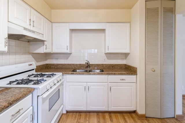 kitchen featuring white cabinets, a sink, light wood-style flooring, white gas range, and under cabinet range hood