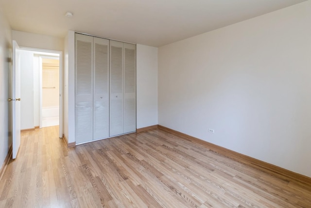 unfurnished bedroom featuring baseboards, a closet, and light wood finished floors