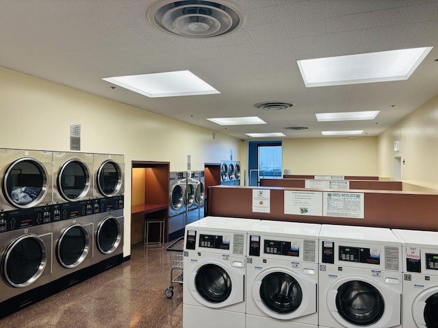 shared laundry room featuring separate washer and dryer, estacked washer and dryer, and a skylight
