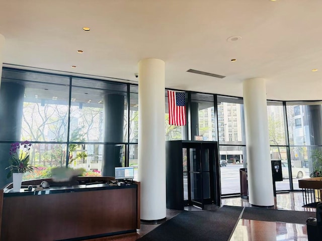 common area with a wall of windows and recessed lighting