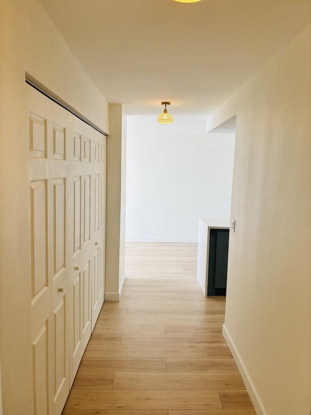 hallway with baseboards and light wood-type flooring