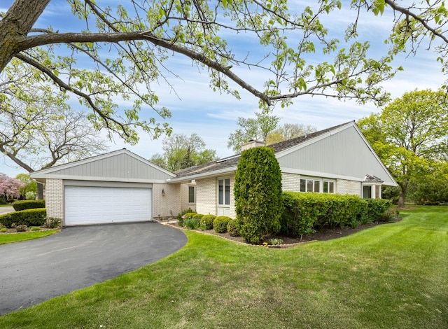 single story home featuring driveway, brick siding, an attached garage, and a front yard