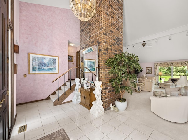 entrance foyer featuring a notable chandelier, light tile patterned floors, a high ceiling, and stairs