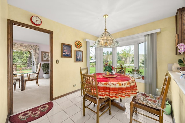 dining room with light tile patterned floors, a wealth of natural light, a notable chandelier, and baseboards