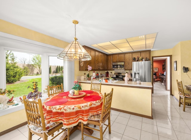 dining room with baseboards, light tile patterned flooring, and a notable chandelier