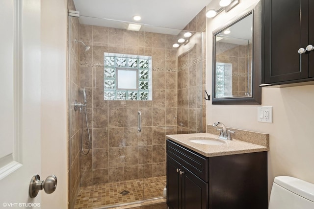 full bath featuring vanity, a stall shower, and toilet