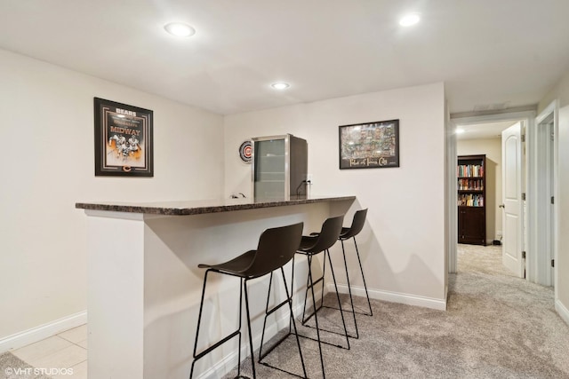 bar with recessed lighting, baseboards, light colored carpet, and a bar