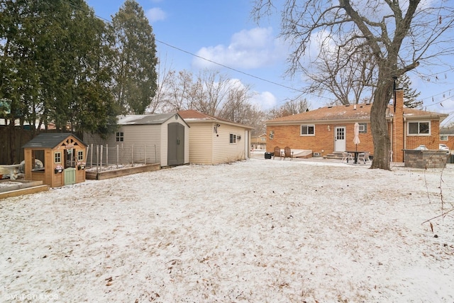 back of property with a storage unit, fence, an outbuilding, and entry steps