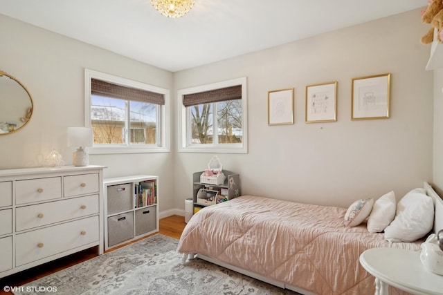 bedroom featuring baseboards and wood finished floors