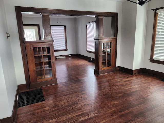 257 S Alma Ave, Kankakee, IL 60901 - unfurnished living room featuring baseboards, dark wood-style floors, and a healthy amount of sunlight