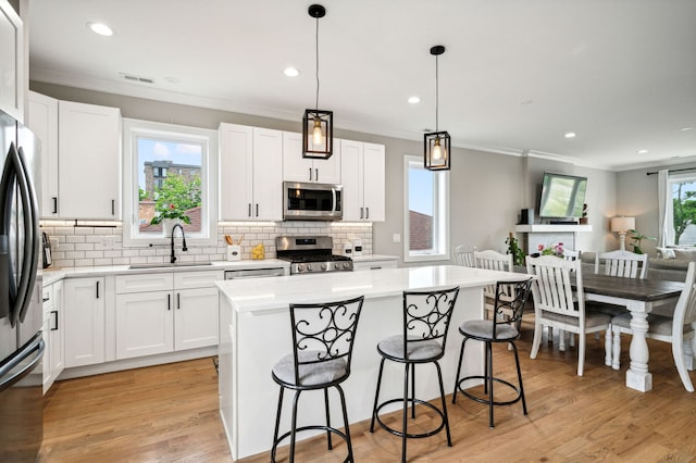 7230 W Belden Ave Unit 3, Elmwood Park, IL 60707 - kitchen featuring stainless steel appliances, a sink, crown molding, a kitchen breakfast bar, and decorative backsplash