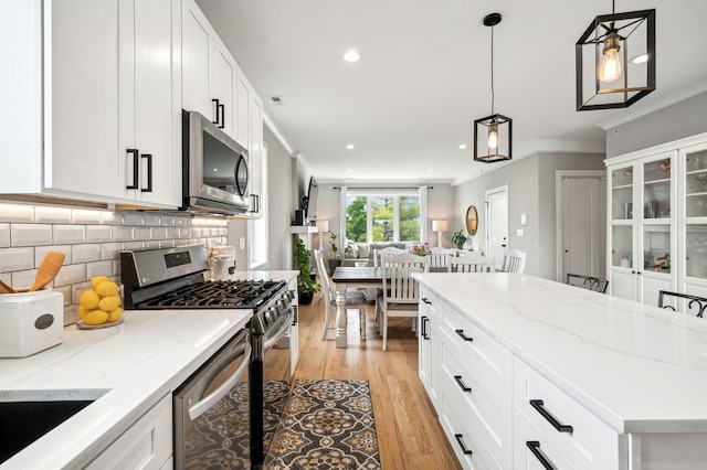 7230 W Belden Ave Unit 3, Elmwood Park, IL 60707 - kitchen featuring stainless steel appliances, crown molding, light wood-style floors, backsplash, and open floor plan