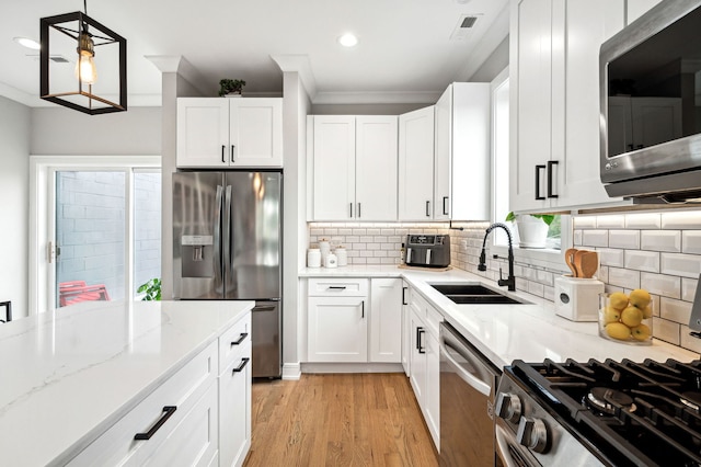 7230 W Belden Ave Unit 3, Elmwood Park, IL 60707 - kitchen with stainless steel appliances, a sink, ornamental molding, light stone countertops, and white cabinetry