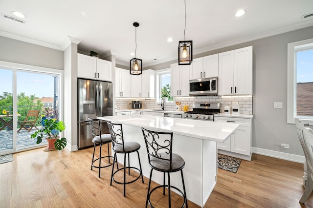 7230 W Belden Ave Unit 3, Elmwood Park, IL 60707 - kitchen featuring stainless steel appliances, a breakfast bar area, ornamental molding, light wood-style flooring, and tasteful backsplash